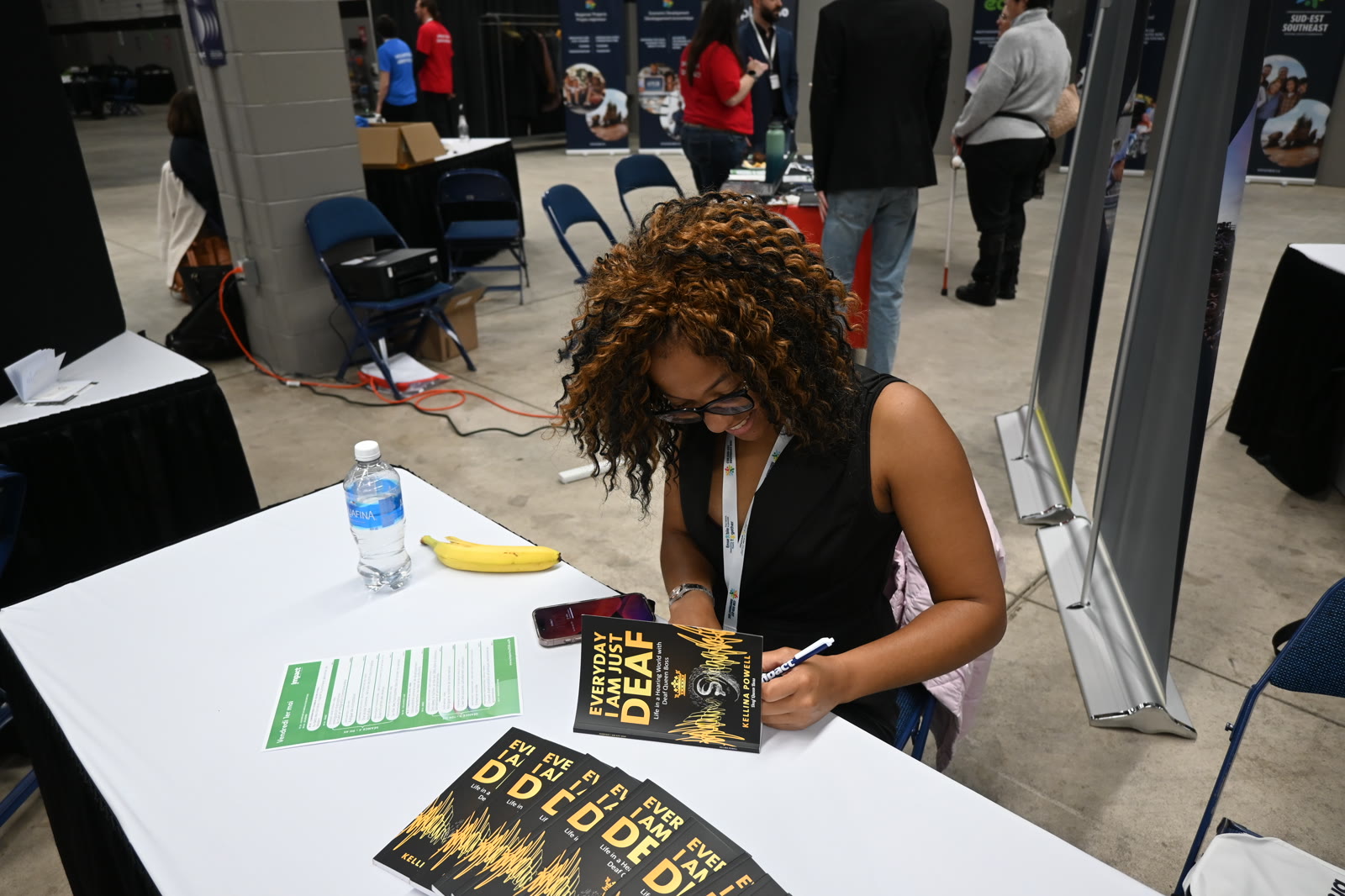 Kellina Powell signing copies of her book for readers